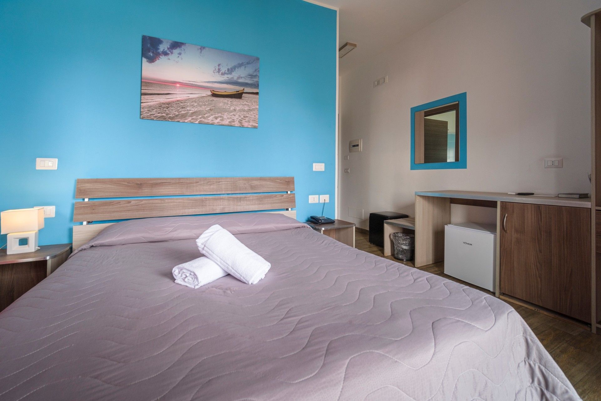 A bedroom with a bed and a blue wall.