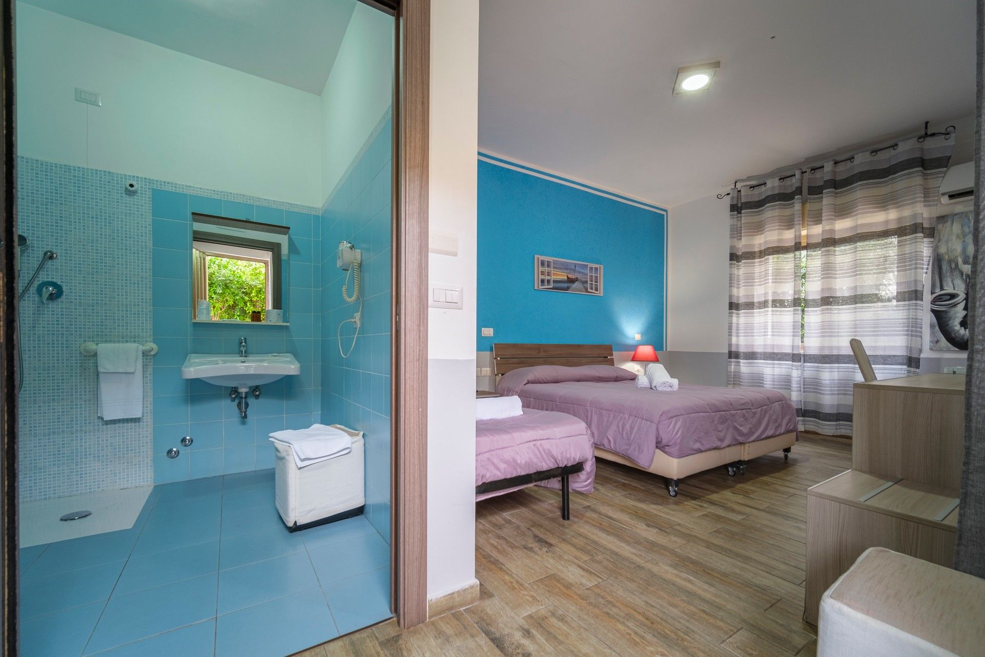 A room with two beds, a washbasin and a bathroom.