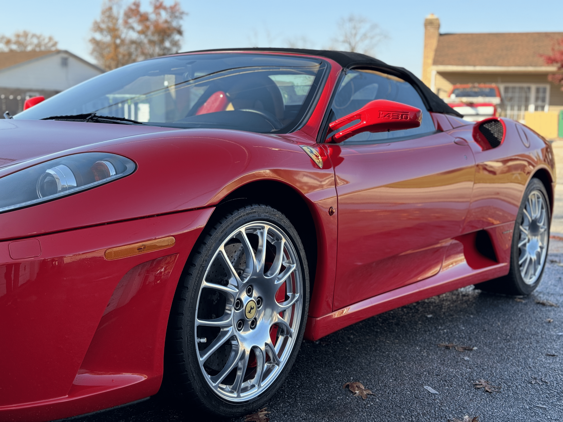 a red ferrari sports car is parked in front of a house .