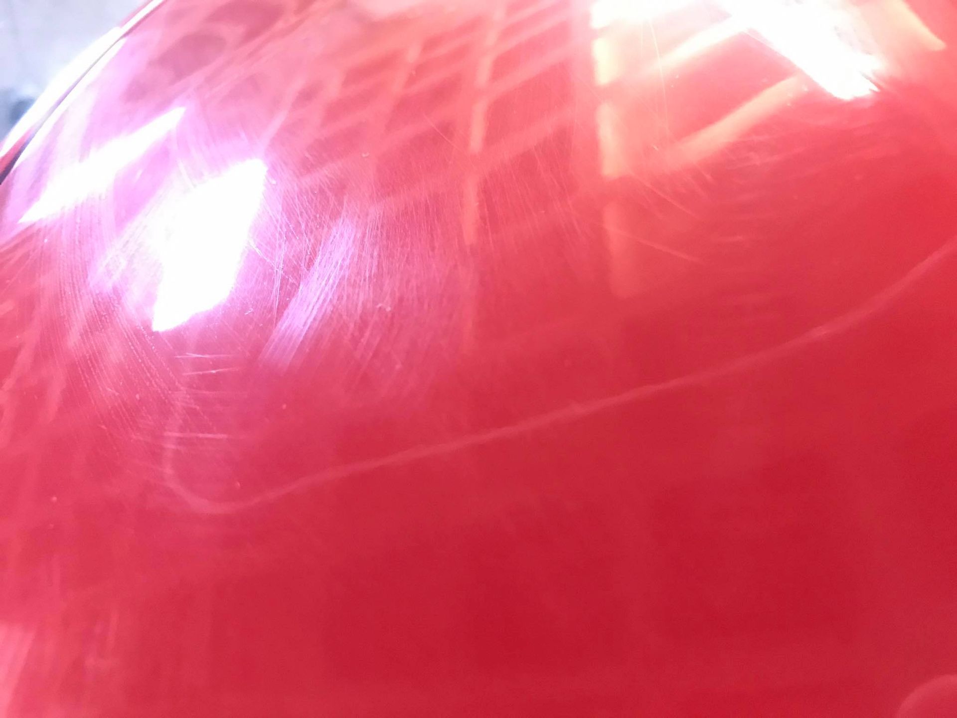 a close up of a red balloon with a light shining on it .