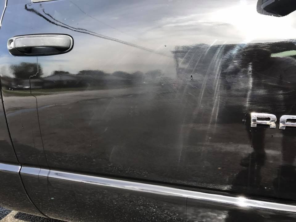 a black ford truck is parked on the side of the road .