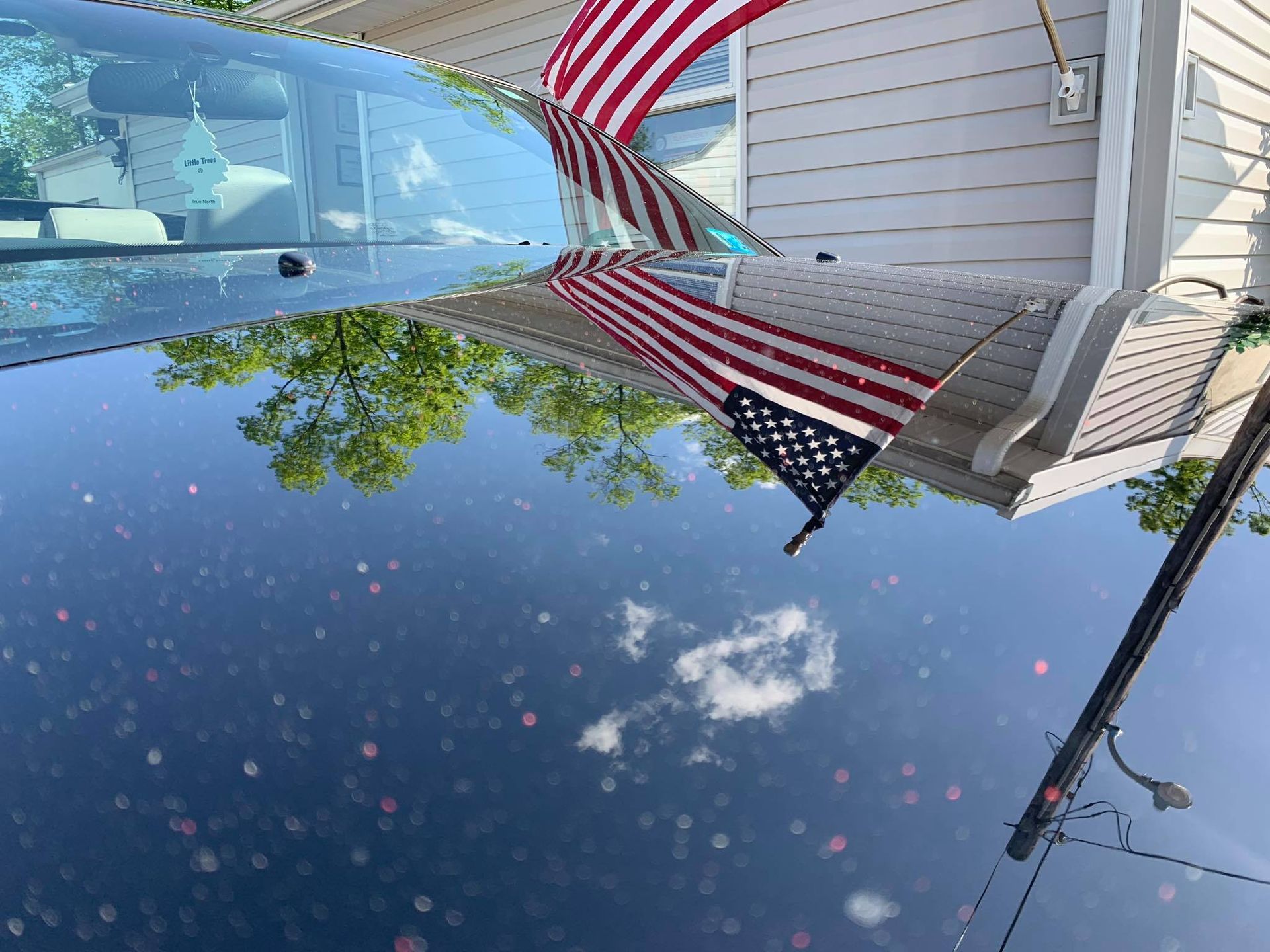 an american flag is reflected in the windshield of a car