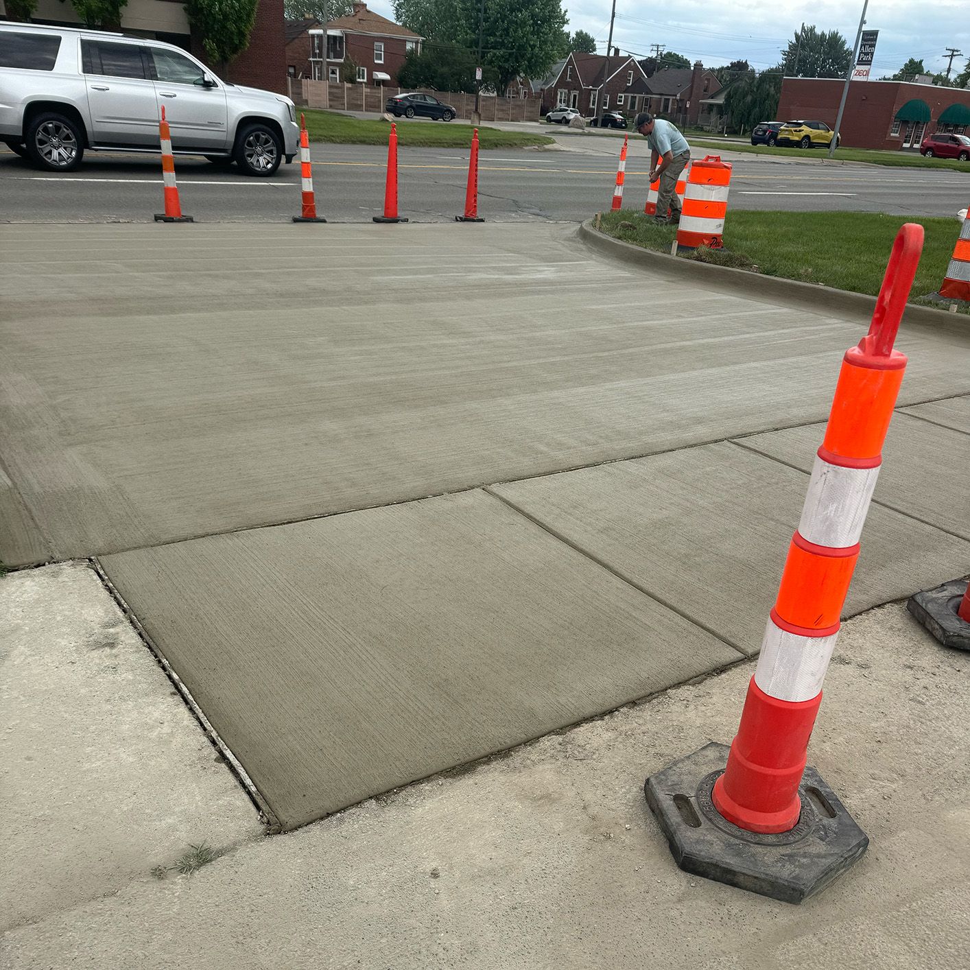 A row of orange and white traffic cones on a sidewalk
