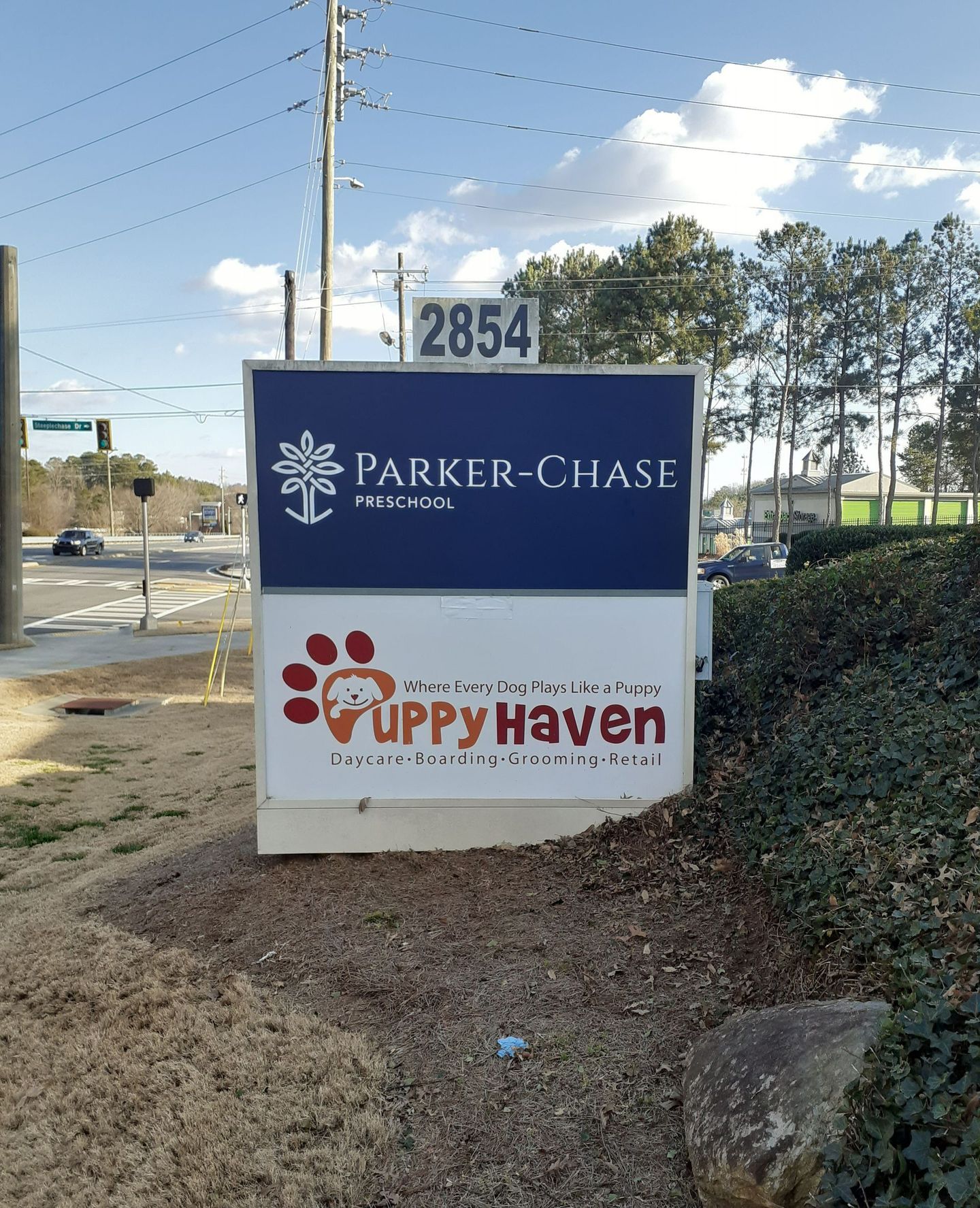 Sign for Parker-Chase Preschool and Puppy Haven, located at 2854. Features a blue and white design with logo and address.