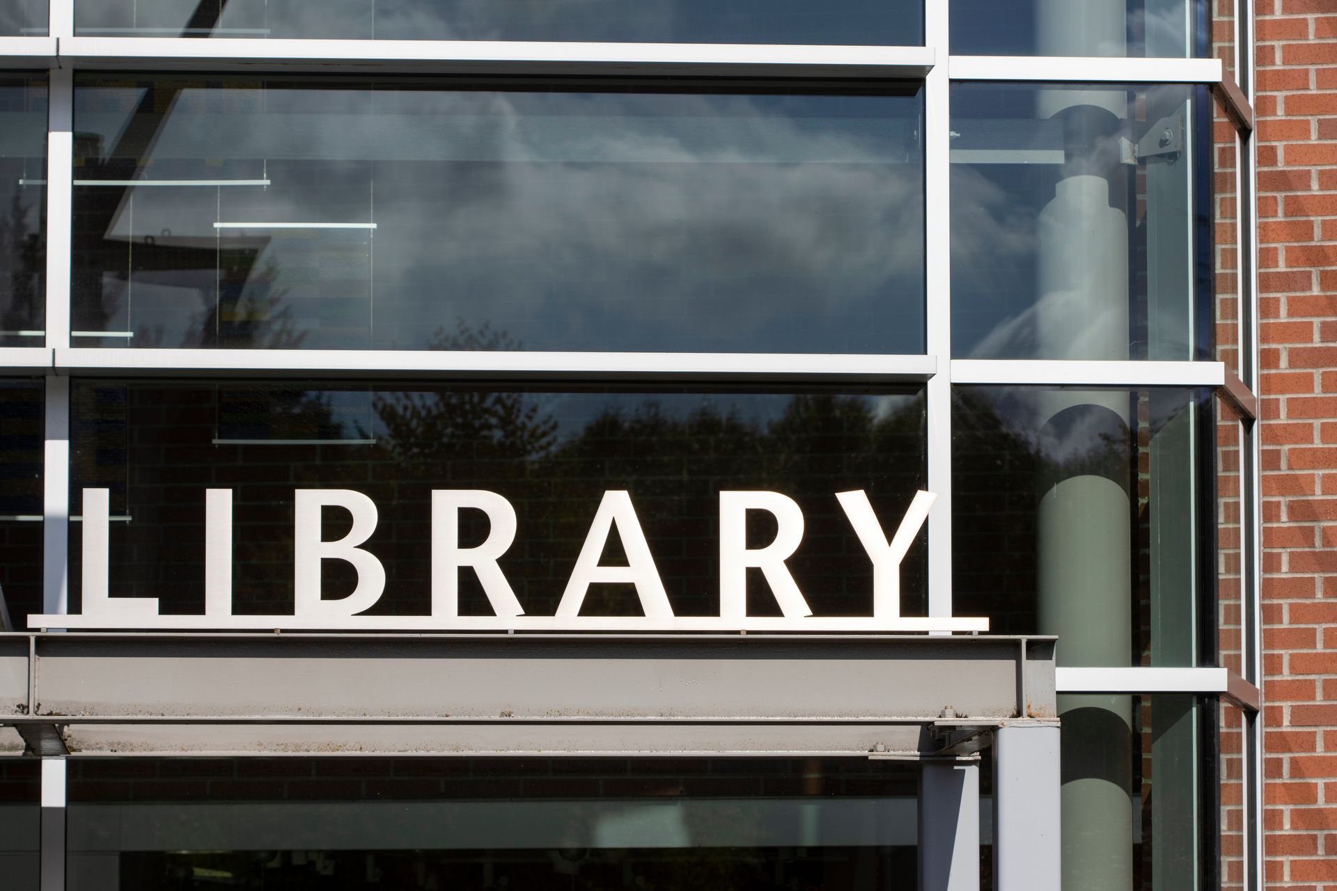 Exterior library sign mounted on modern building facade.