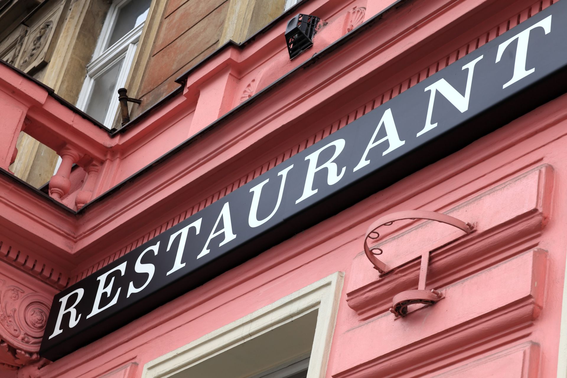 Bold RESTAURANT sign pops on pink storefront with vintage trim. Bold RESTAURANT sign pops on pink storefront with vintage trim.