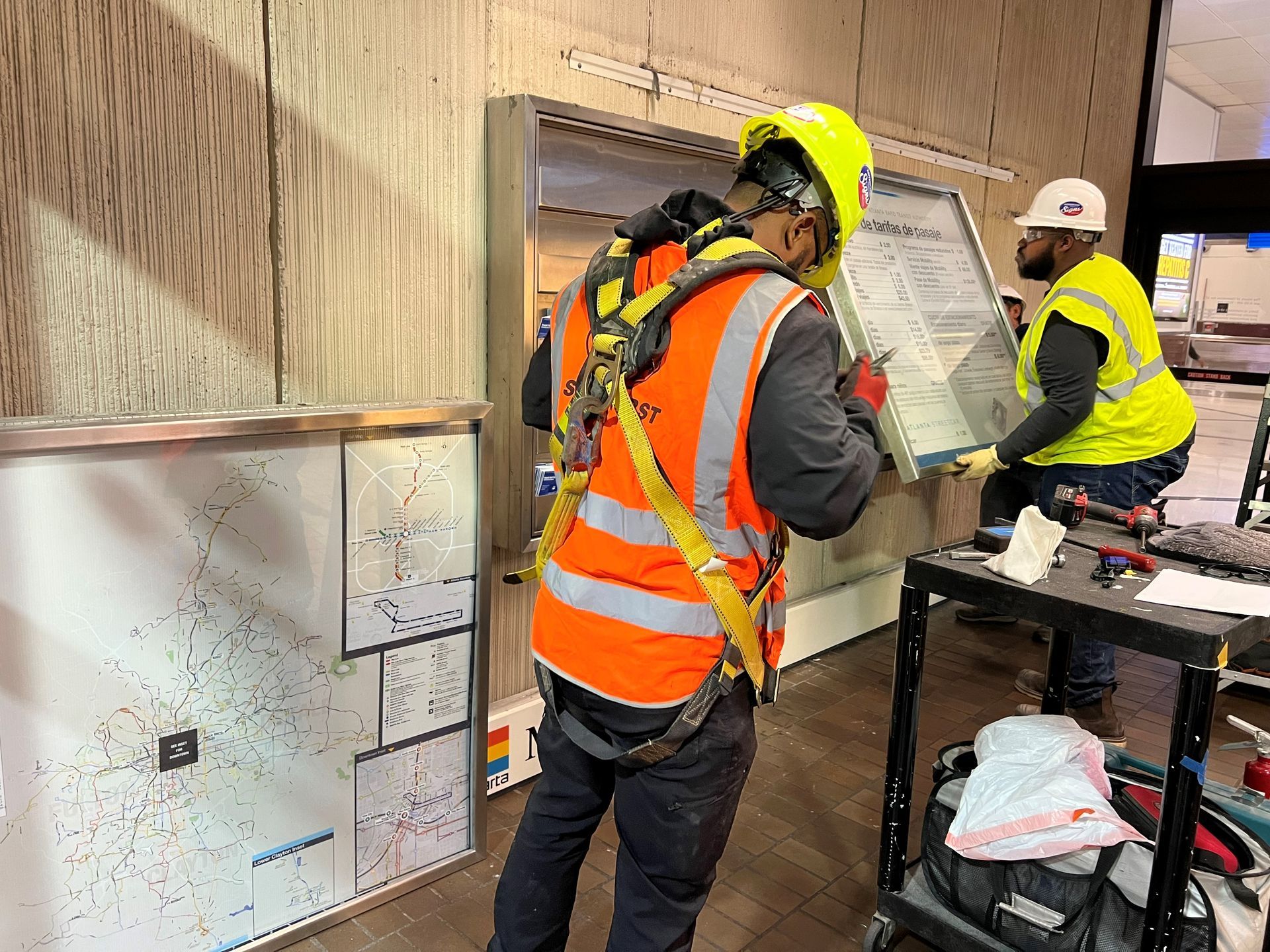 Two construction workers are working on a wall.