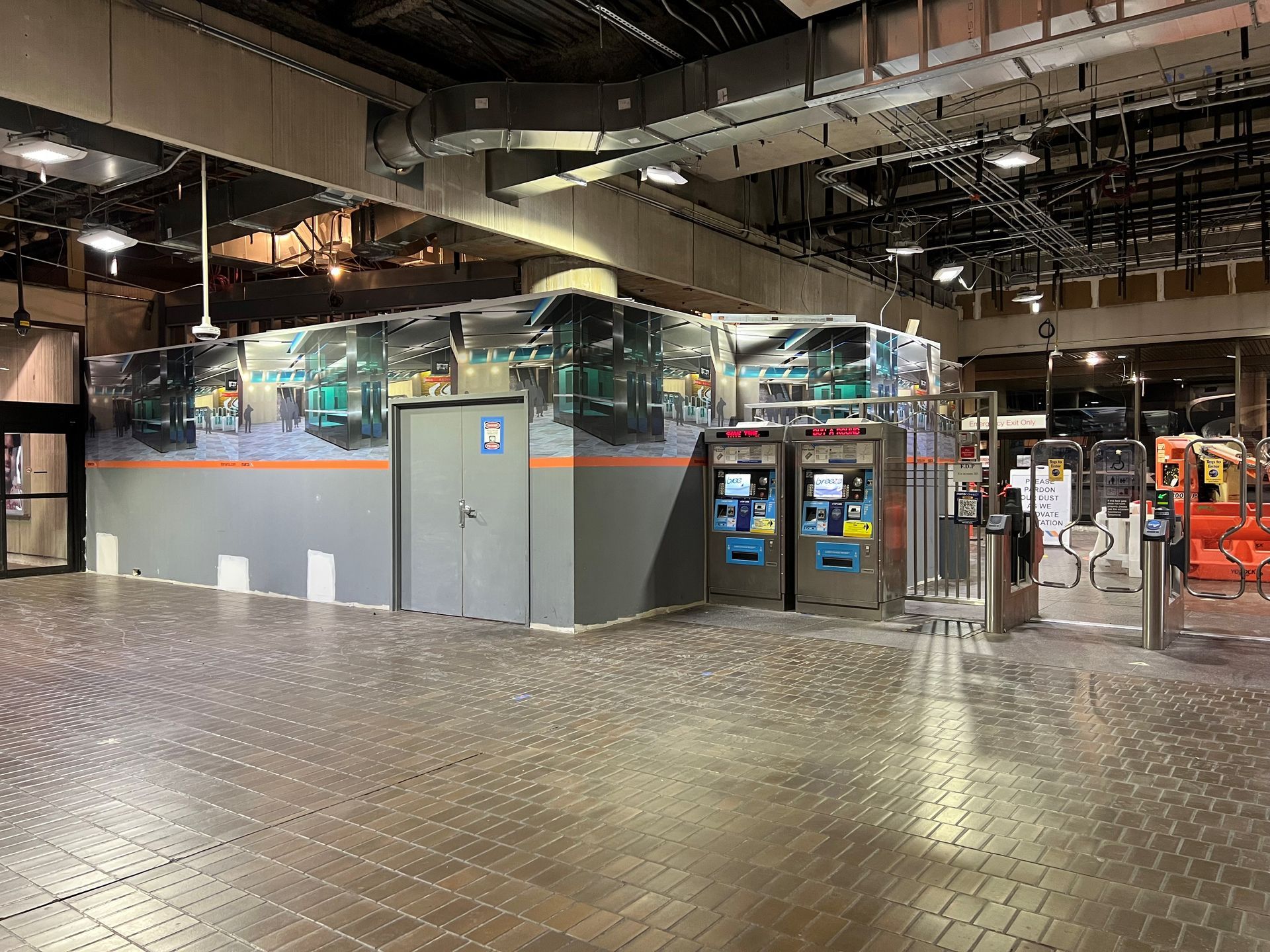 A large empty building with a brick floor and a few vending machines