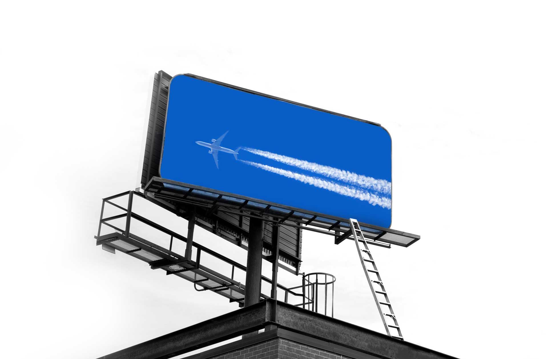 Billboard showing an airplane with contrails against a blue sky with clouds. Billboard showing an airplane with contrails against a blue sky with clouds.