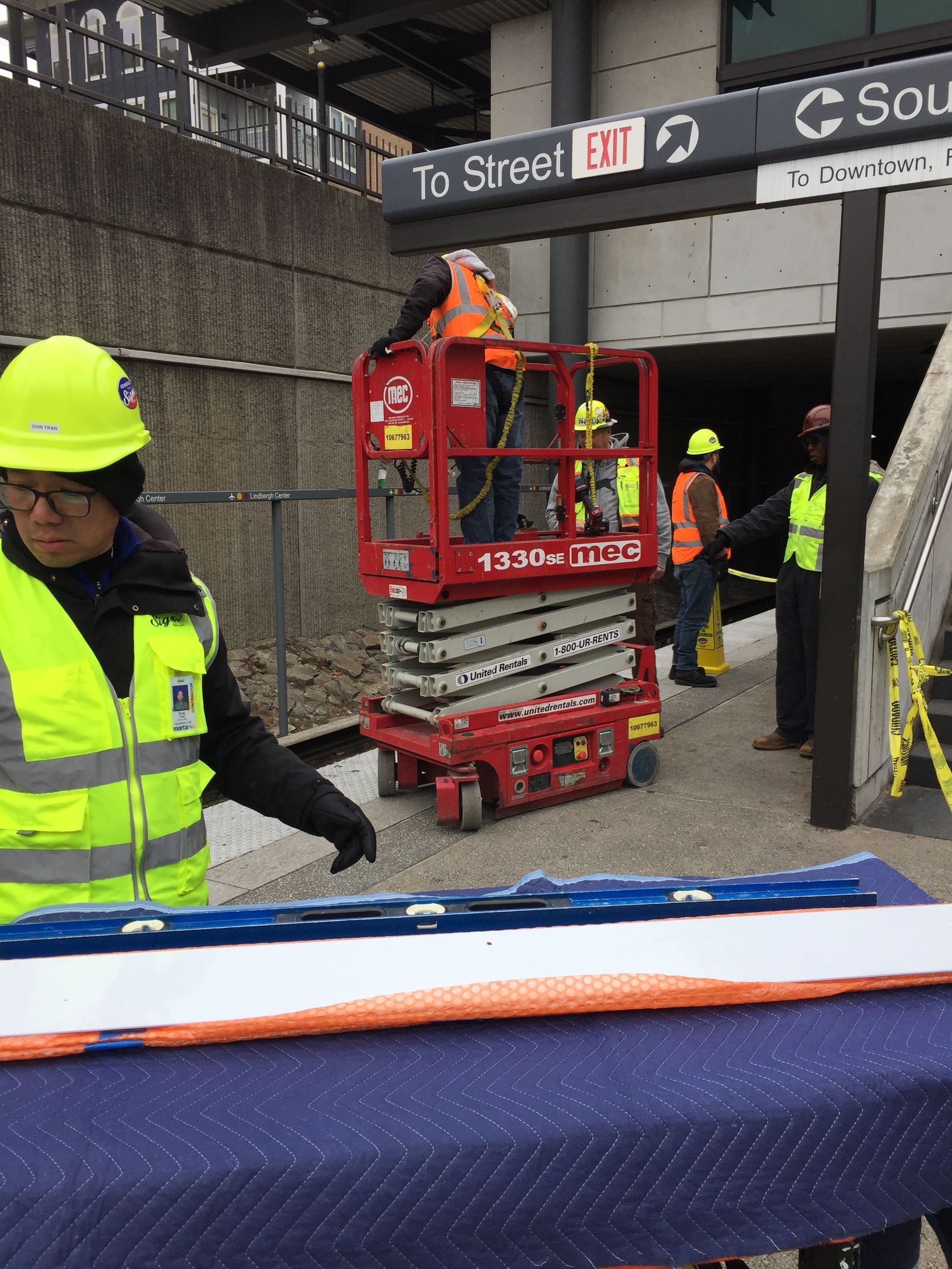 Two construction workers are working on a wall.