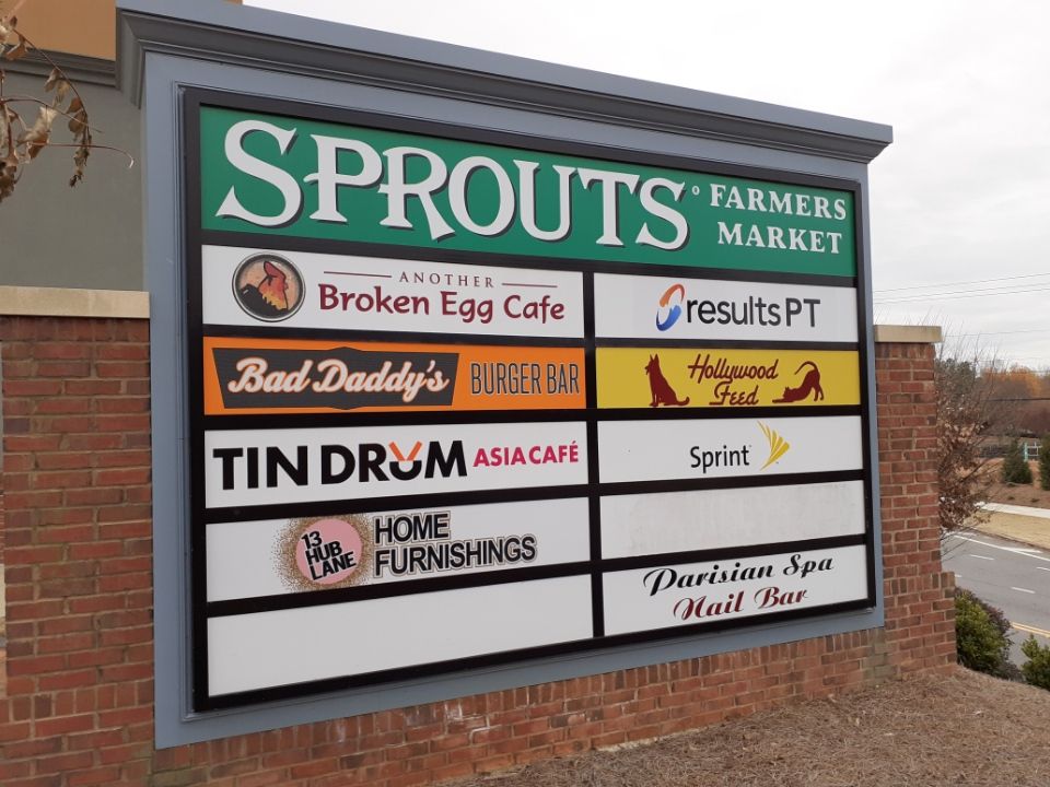 Sign for a shopping center with Sprouts Farmers Market and various other businesses.