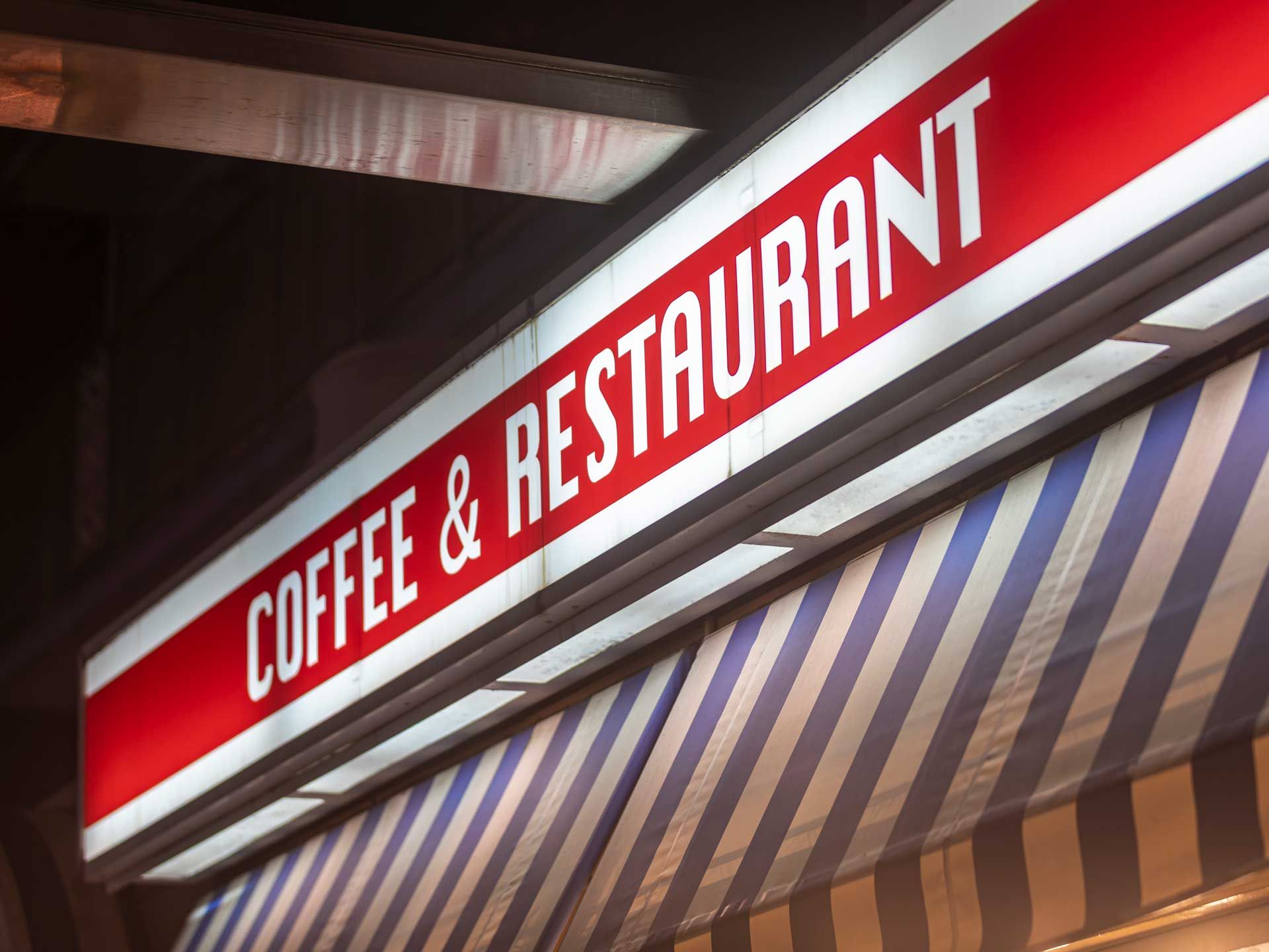 An illuminated red and white sign reading 