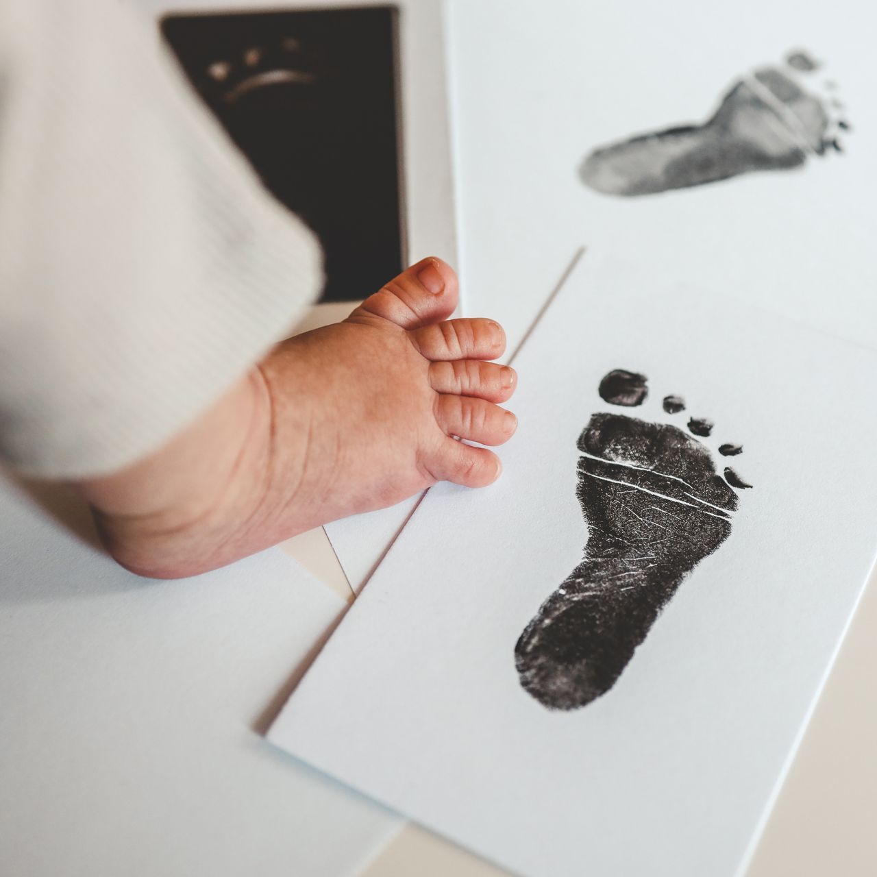 Image of child's foot and footprint on a piece of paper.