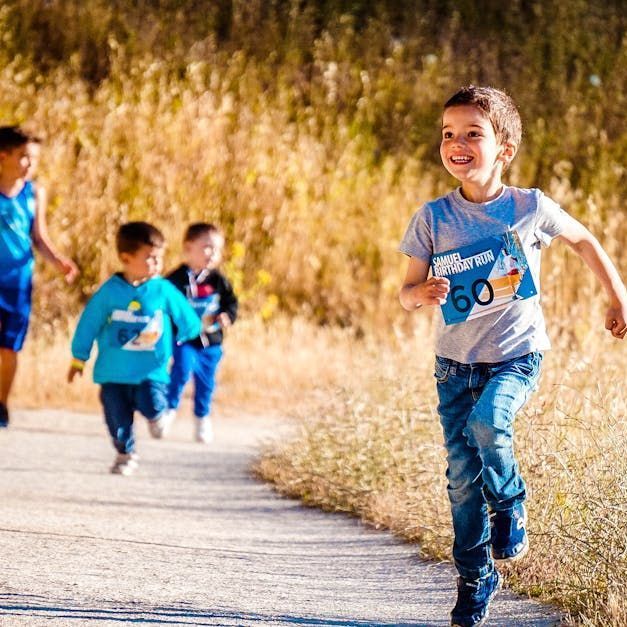 Young boys running outside with smiles.