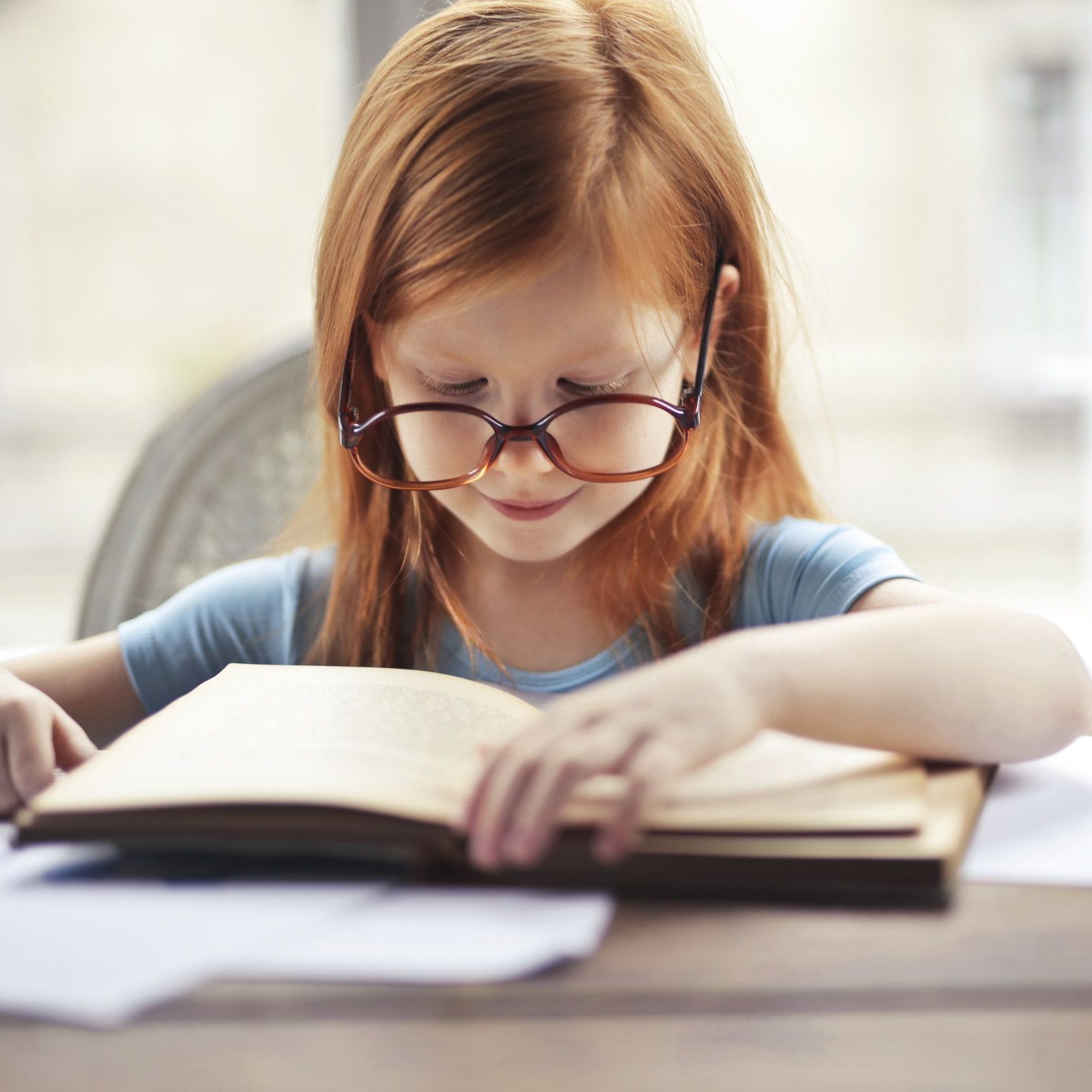 Image of redhead girl reading a book.