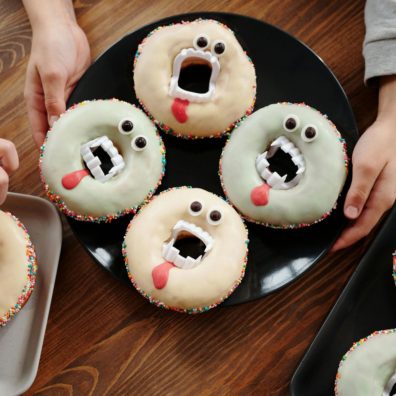 Assorted Halloween-themed donuts decorated with candy eyes, vampire teeth, and red icing to resemble