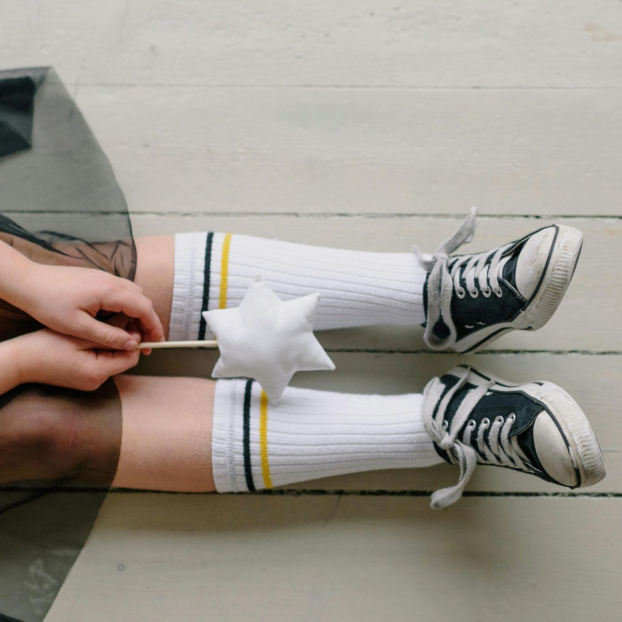 Image of young girl with sneakers and athletic socks pulled up.