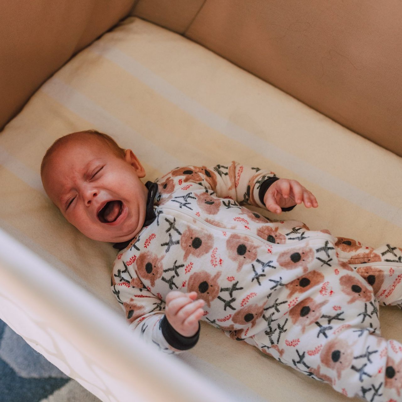 Image of infant crying alone in crib