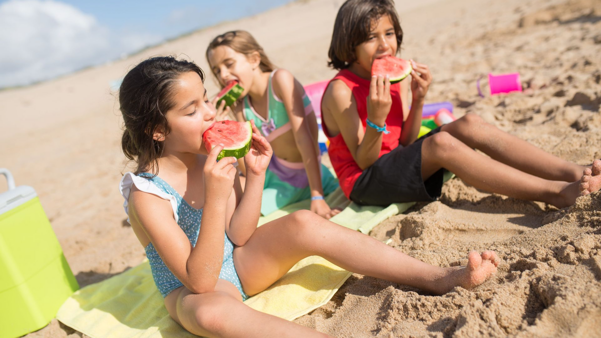 Children enjoying healthy frozen treats while relaxing on a sandy beach during summer vacation, prom