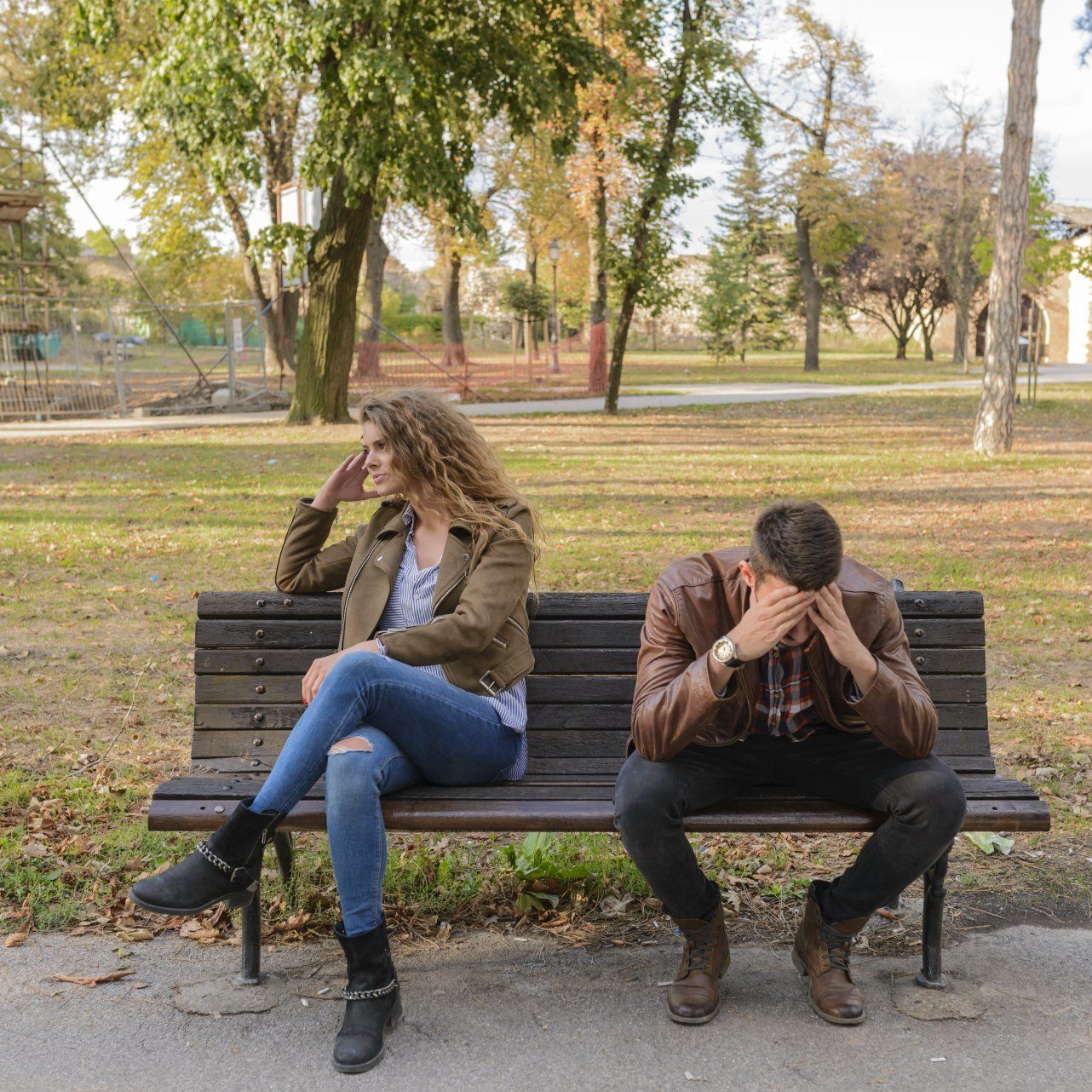 Image of stressed couple sitting on a park bench.