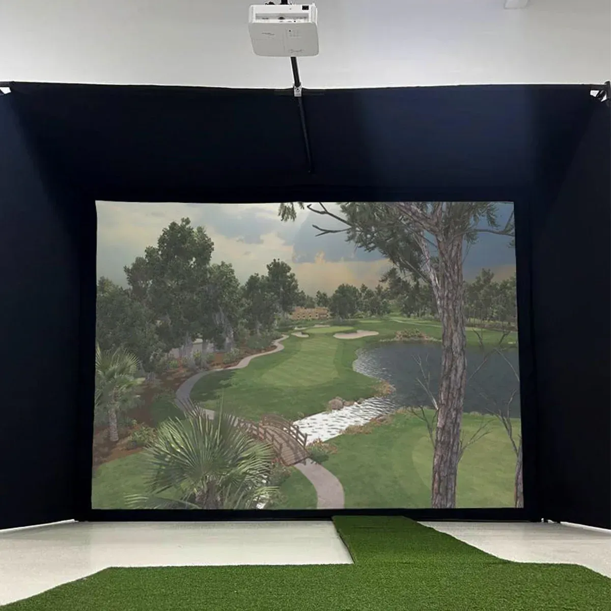 A golf simulator with a picture of a golf course on the wall.
