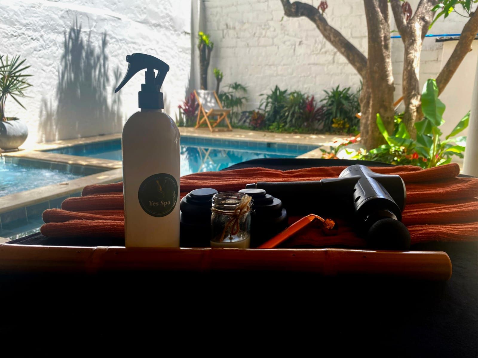 Una botella de spray se encuentra en una bandeja al lado de una piscina.