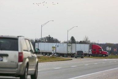 A truck is driving down a highway next to a van.