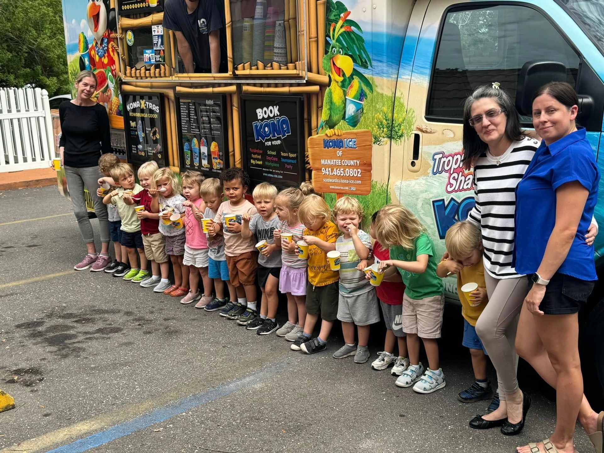 Children and adults with ice cream treats by a colorful truck.