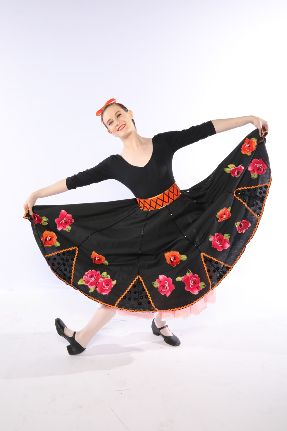A Woman in a Black Dress With Flowers on It is Dancing— Studi-O Dance School In Gateshead, NSW