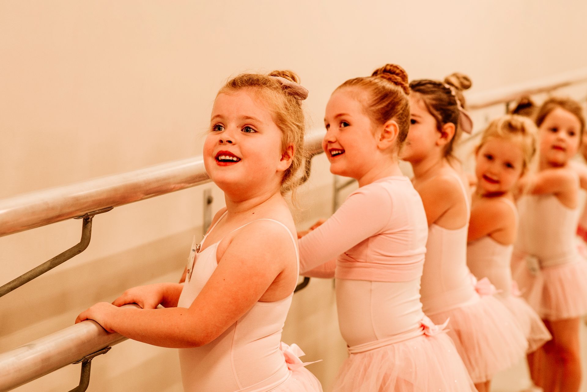 A Group of Young Girls Are Standing Next to Each Other at a Ballet Barre — Studi-O Dance School In Gateshead, NSW