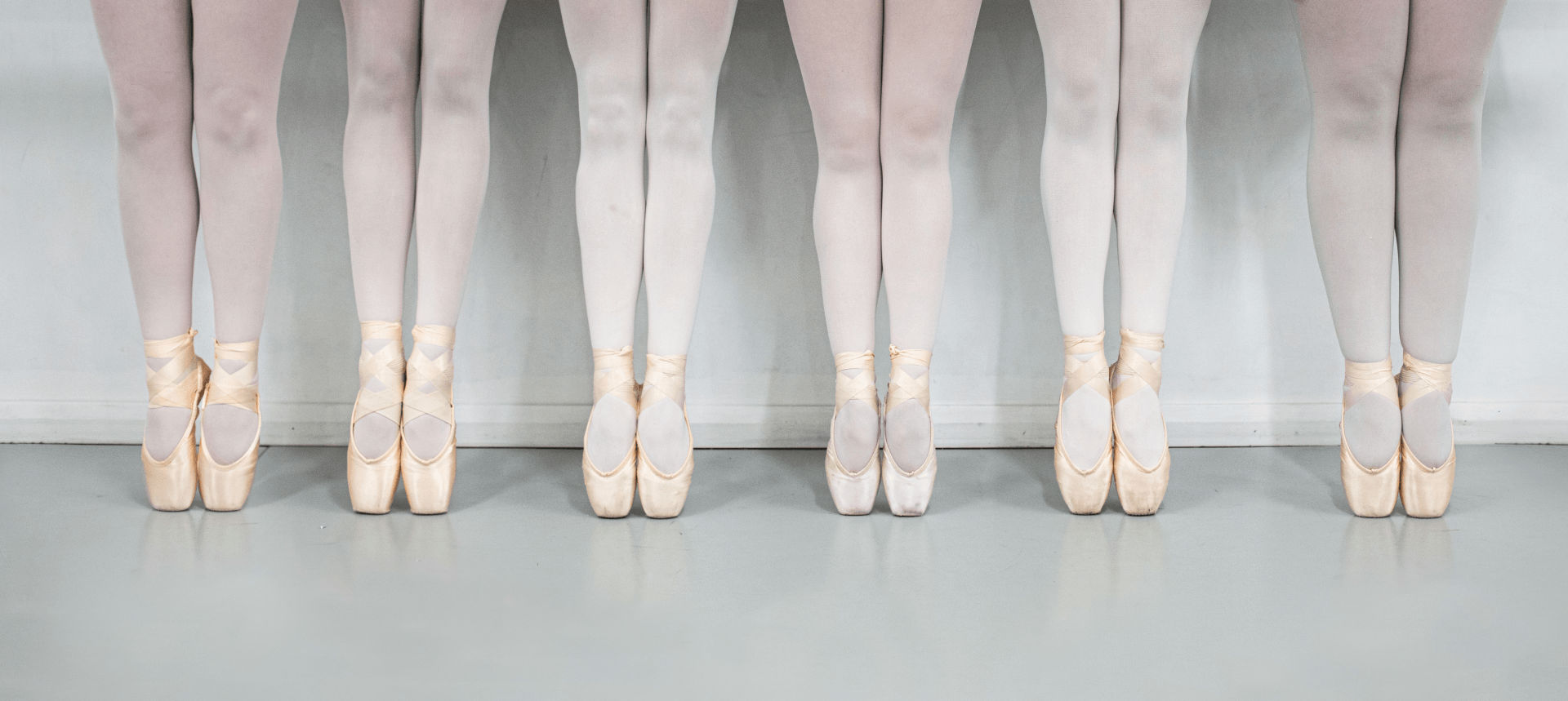 A group of ballet dancers are standing in a row wearing pointe shoes — Studi-O Dance School In Gateshead, NSW