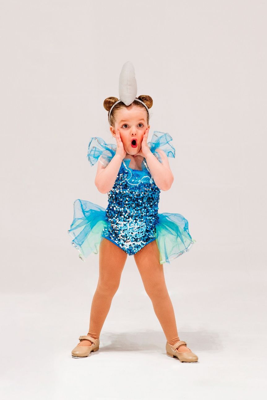 A Little Girl in a Blue Leotard and Tutu is Standing on a White Background — Studi-O Dance School In Gateshead, NSW