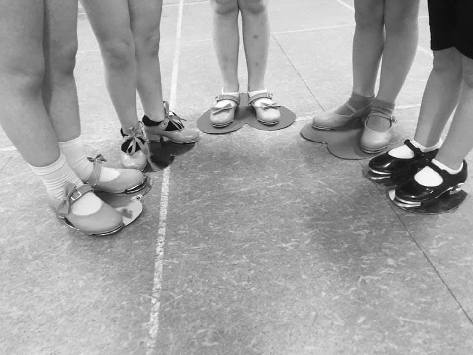 A group of people standing in a circle wearing shoes