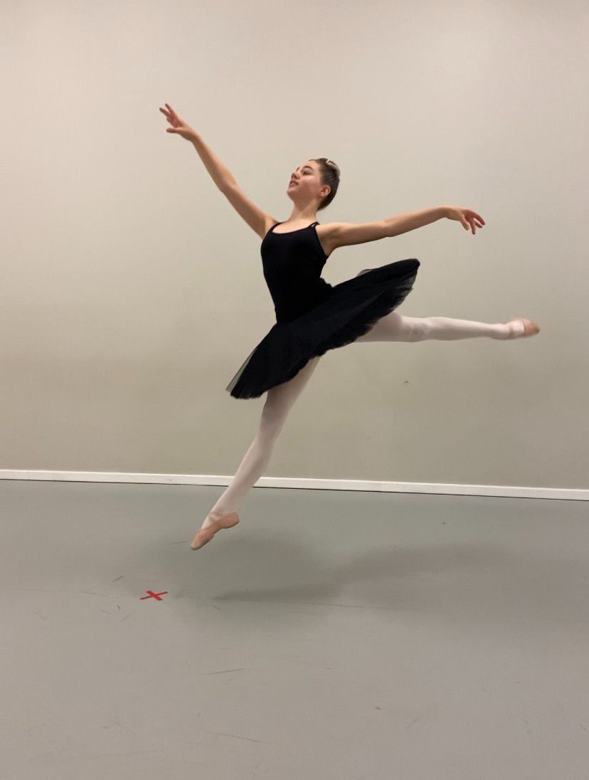 A Ballerina in a Black Tutu is Jumping in the Air — Studi-O Dance School In Gateshead, NSW