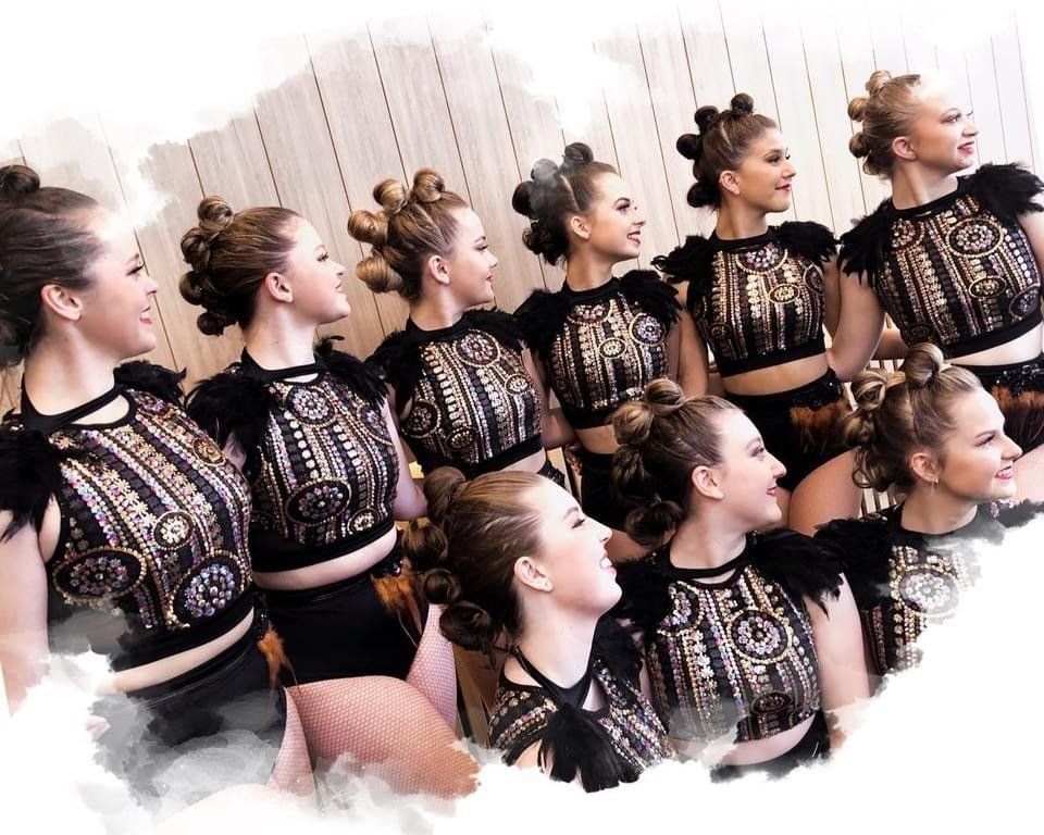 A group of women are standing next to each other wearing black and gold outfits — Studi-O Dance School In Gateshead, NSW