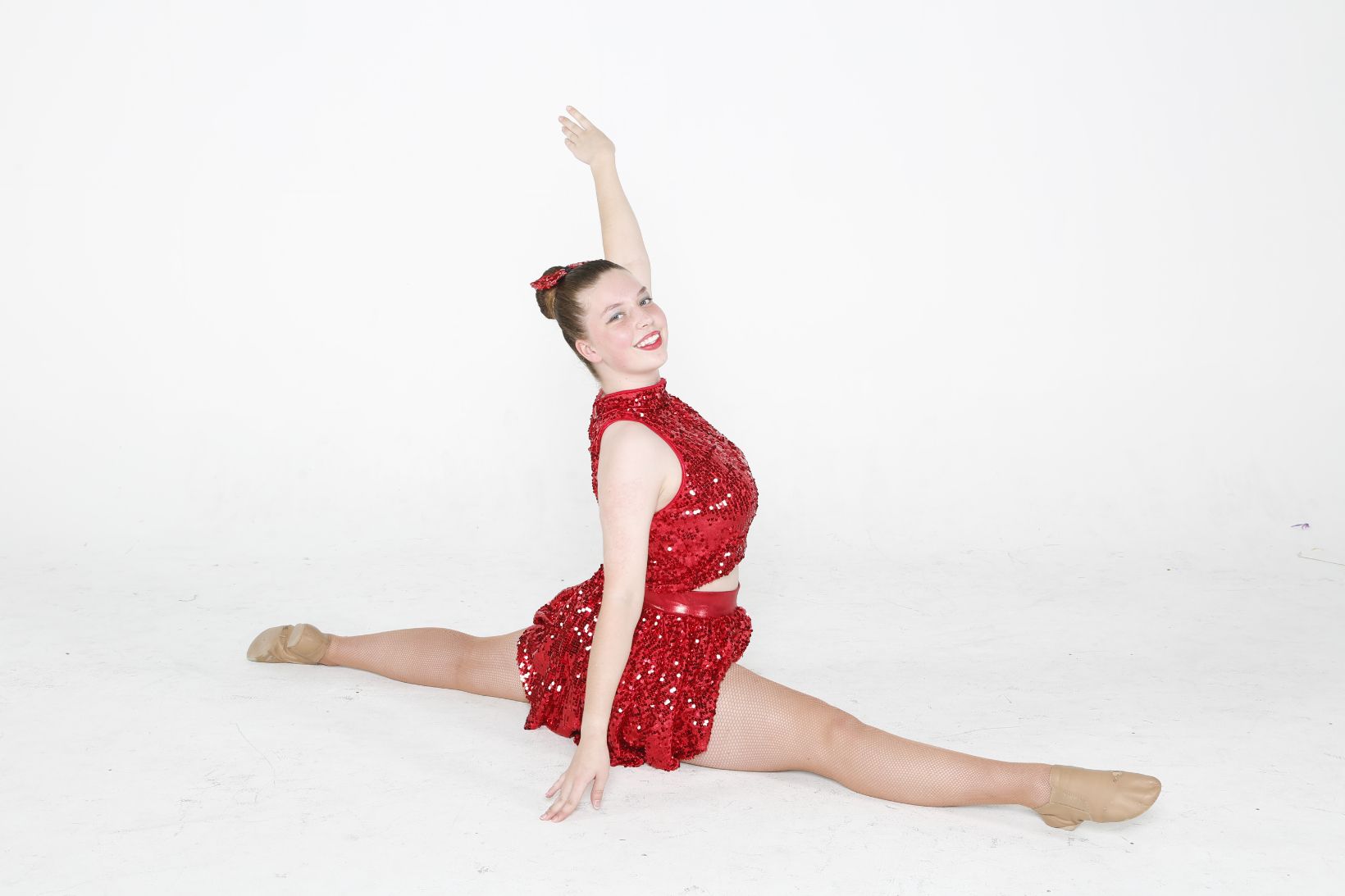 A Woman in a Red Dress is Doing a Split on the Floor — Studi-O Dance School In Gateshead, NSW