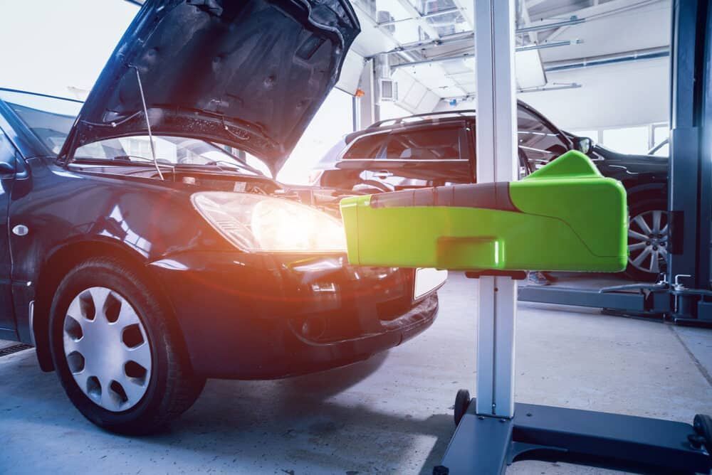 A Car With Its Hood Up Is Sitting On A Lift In A Garage — Warren Ridge Auto Centre In Berkeley Vale, NSW