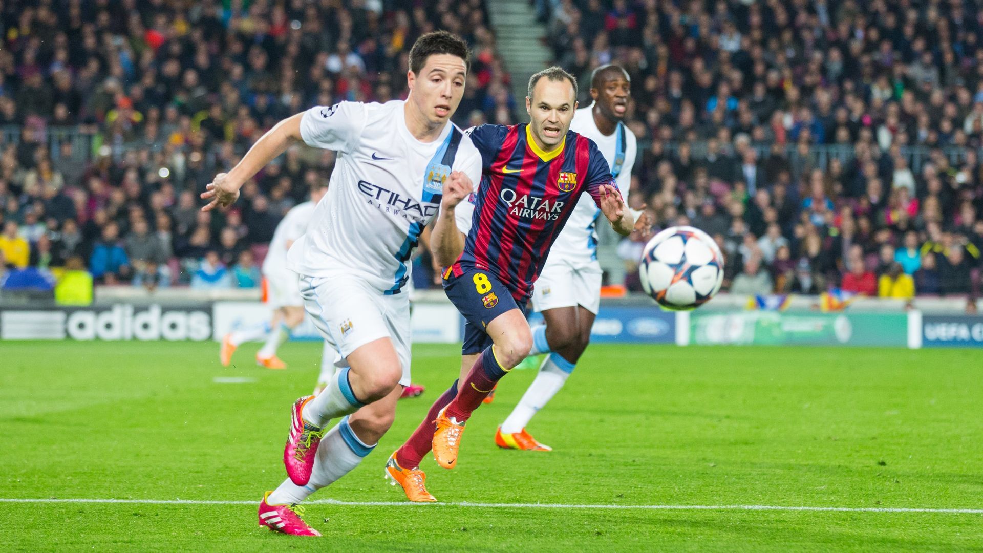 A group of soccer players are playing a game of soccer on a field.