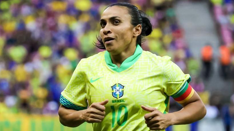 A female soccer player is running on the field during a match.