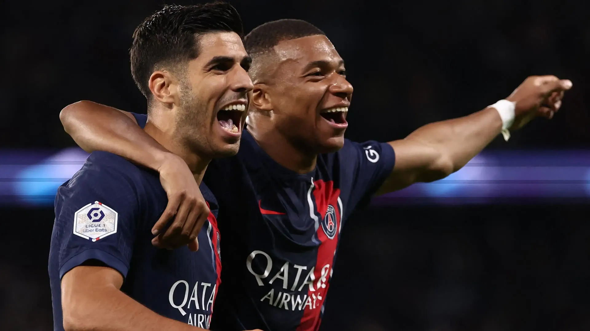 Two soccer players are celebrating a goal together on a field.