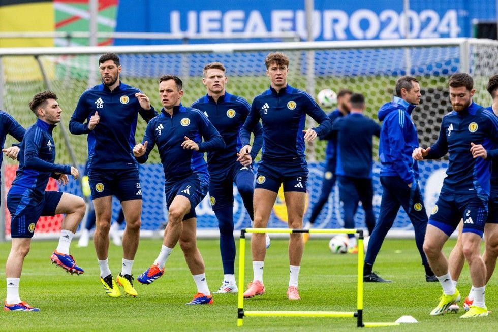A group of soccer players are running on a field.