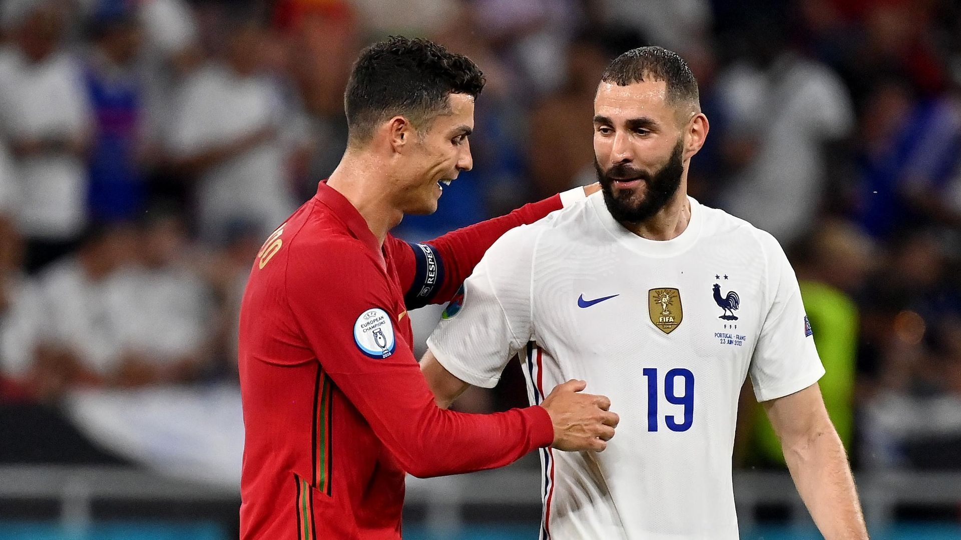 A couple of soccer players are standing next to each other on a field.