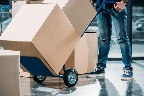 Warehouse Supplier — Person Carrying Boxes on Hand Trucks in Miami, FL