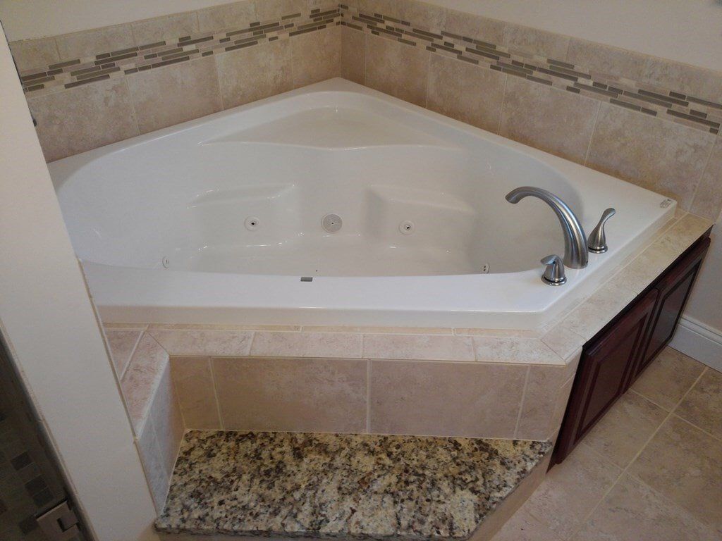 There is a jacuzzi tub in the corner of the bathroom.