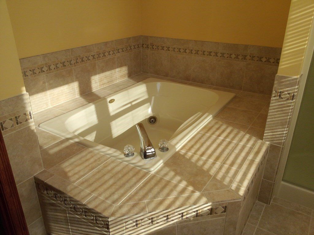 A bathroom with a jacuzzi tub in the corner.