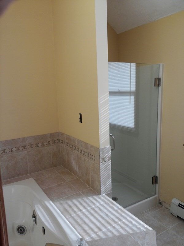 A bathroom with a tub and a walk in shower