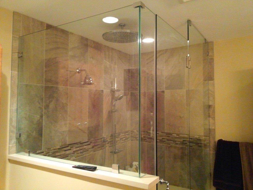 A bathroom with a walk in shower with a glass door