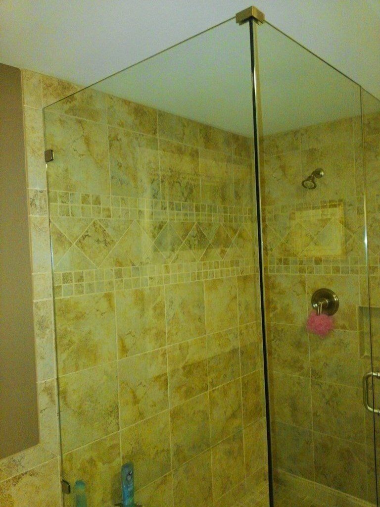 A bathroom with a walk in shower with a glass door