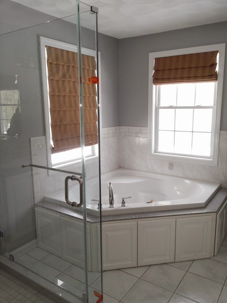 A bathroom with a jacuzzi tub and a walk in shower.