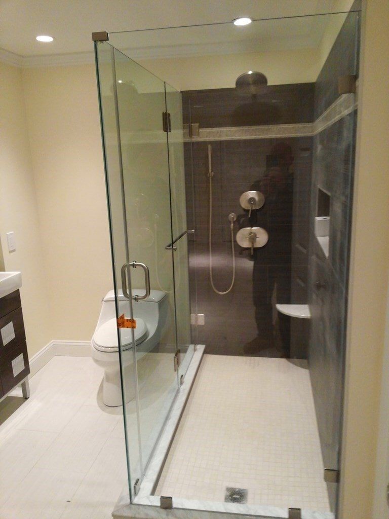 A bathroom with a toilet , sink and walk in shower.